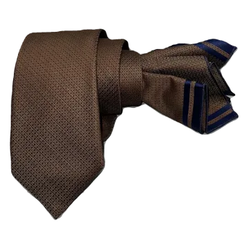 Corbata cobriza con destellos en marino. Pañuelo a juego con ribete marino.
